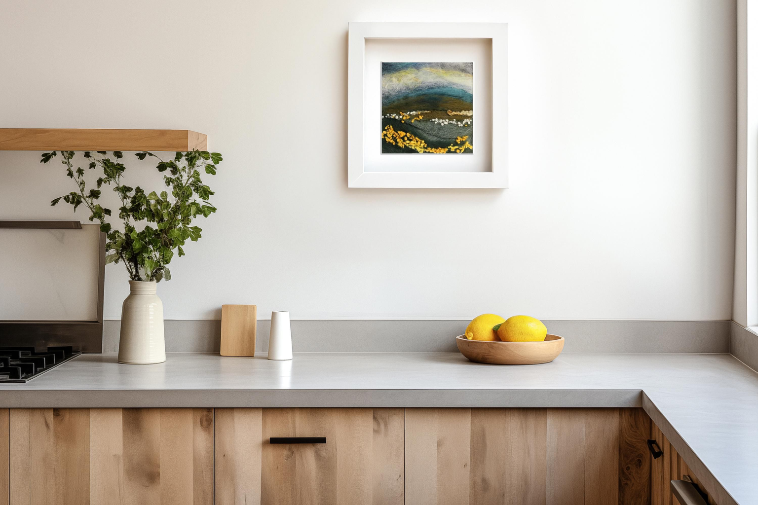 Framed felt landscape displayed above a kitchen counter